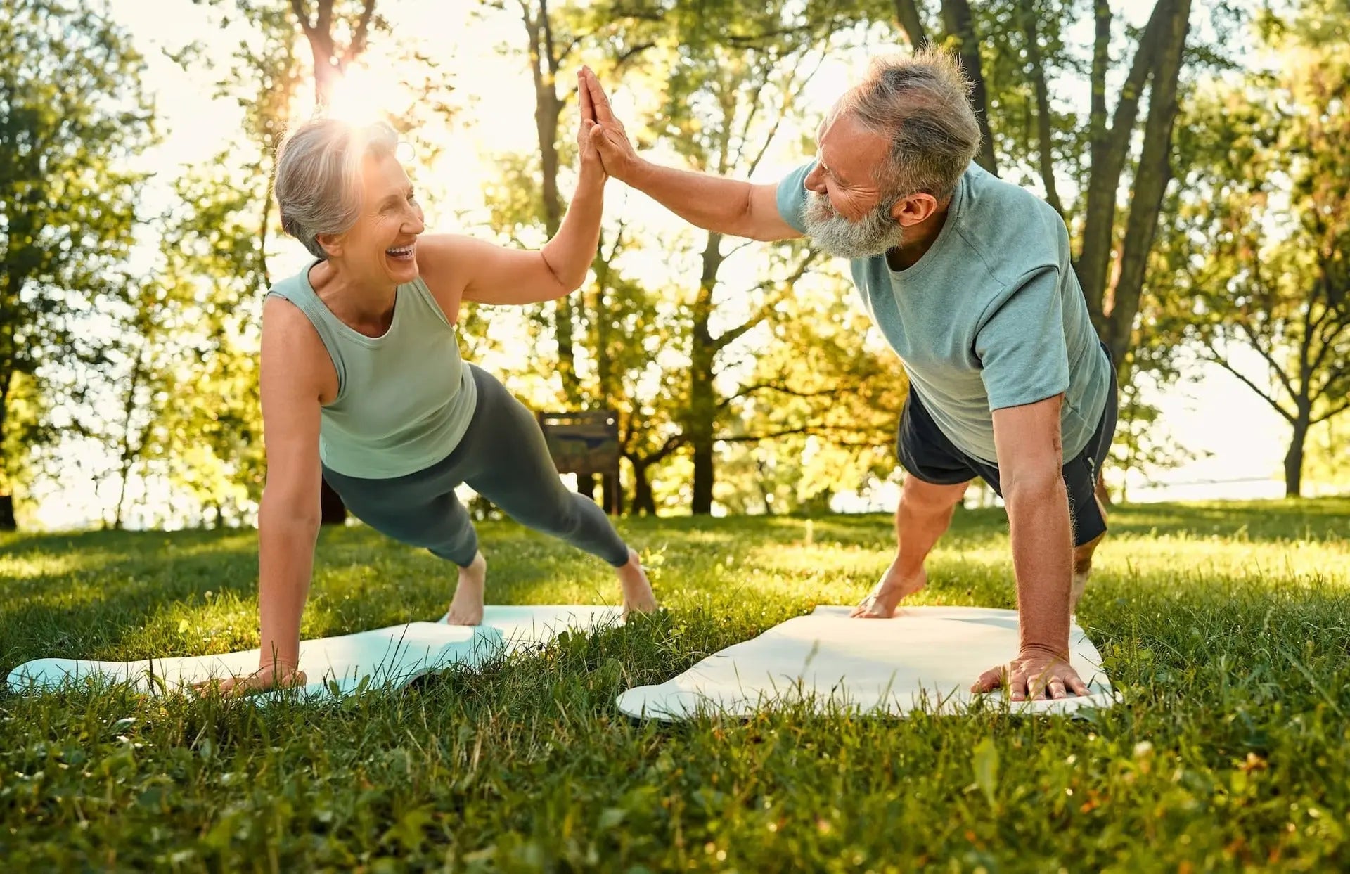 Healthy senior man and woman making high five while in plank position, Why metabolic health matters for aging concept