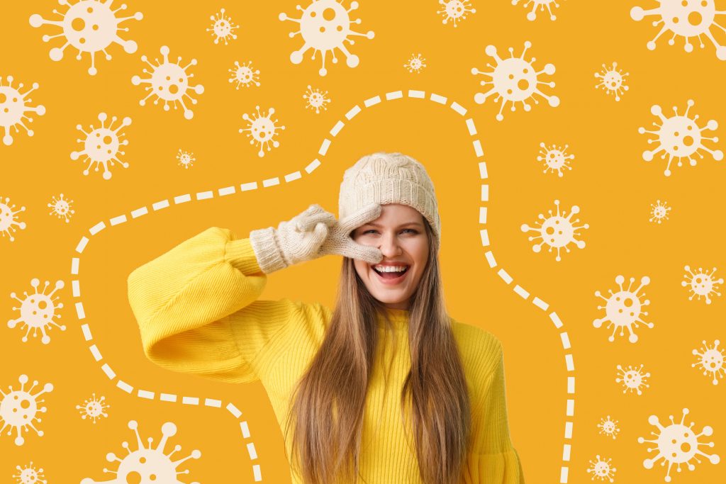 Happy young woman and drawn virus on orange background. Concept of strong natural immune defense