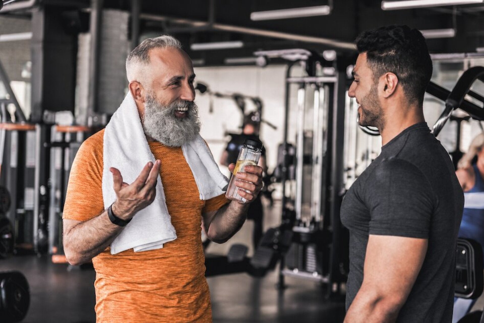Two men in a gym talking about peptides for healthy aging and peptides for weight loss