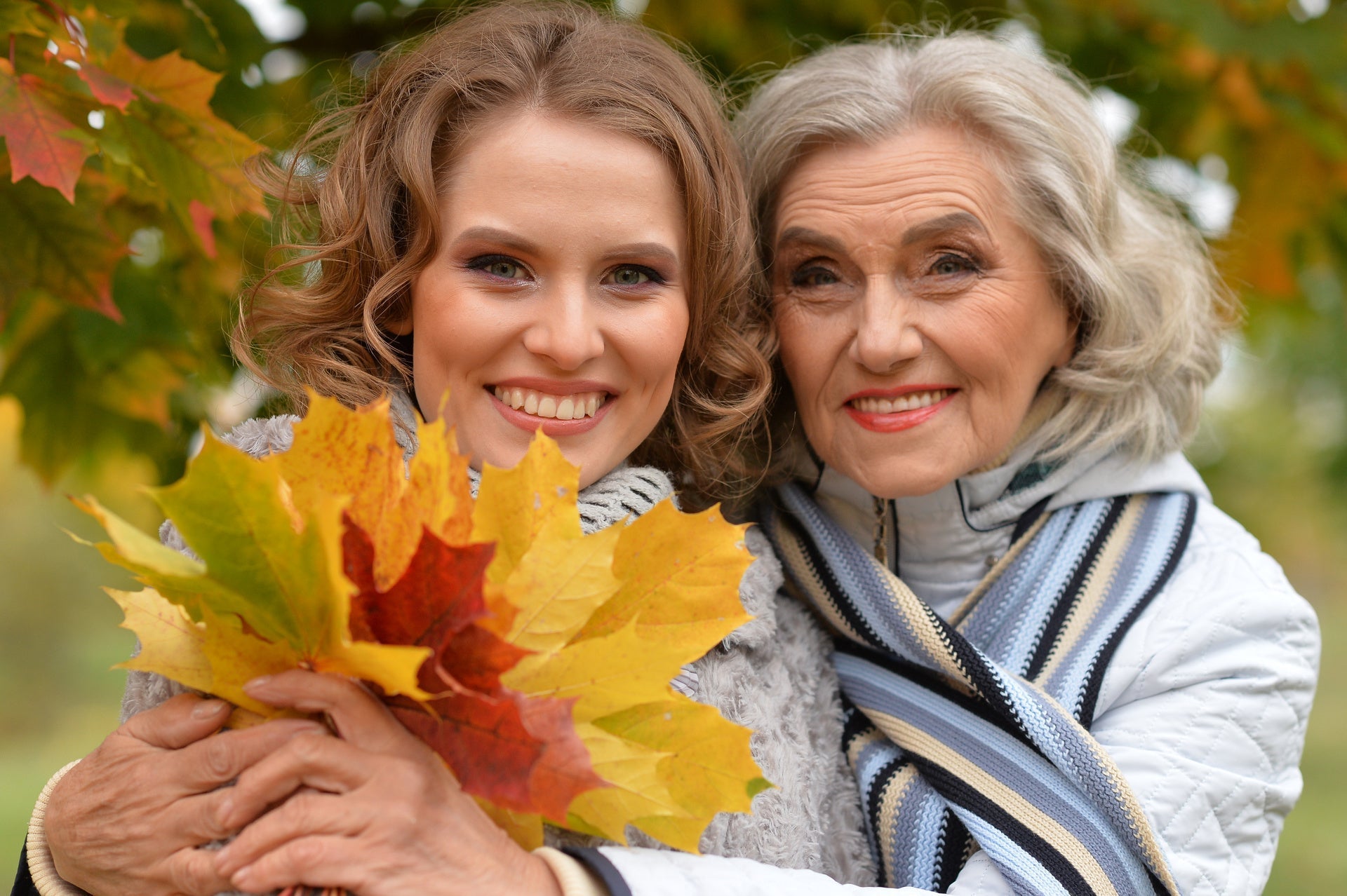 Portrait of an elderly woman with her daughter in autumn.