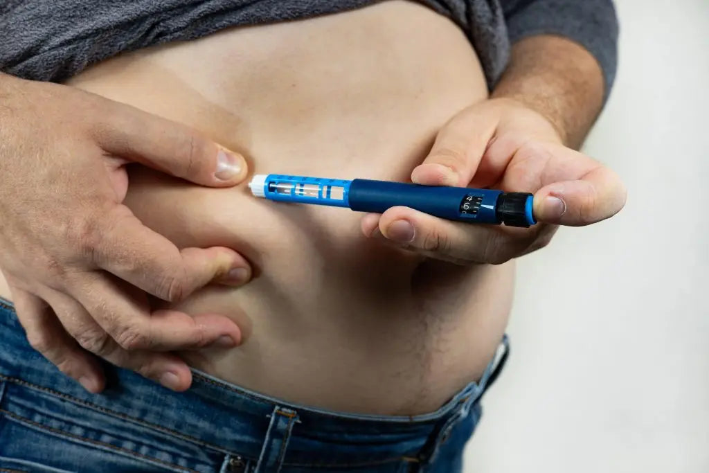man giving himself GLP-1 Receptor Agonists injection at home, for weight loss.