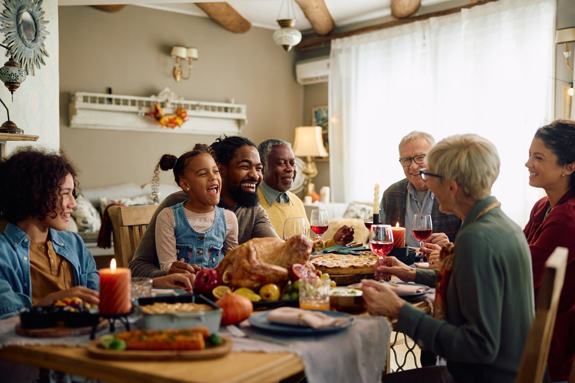 Happy extended family having fun while gathering at dining table for the holiday season