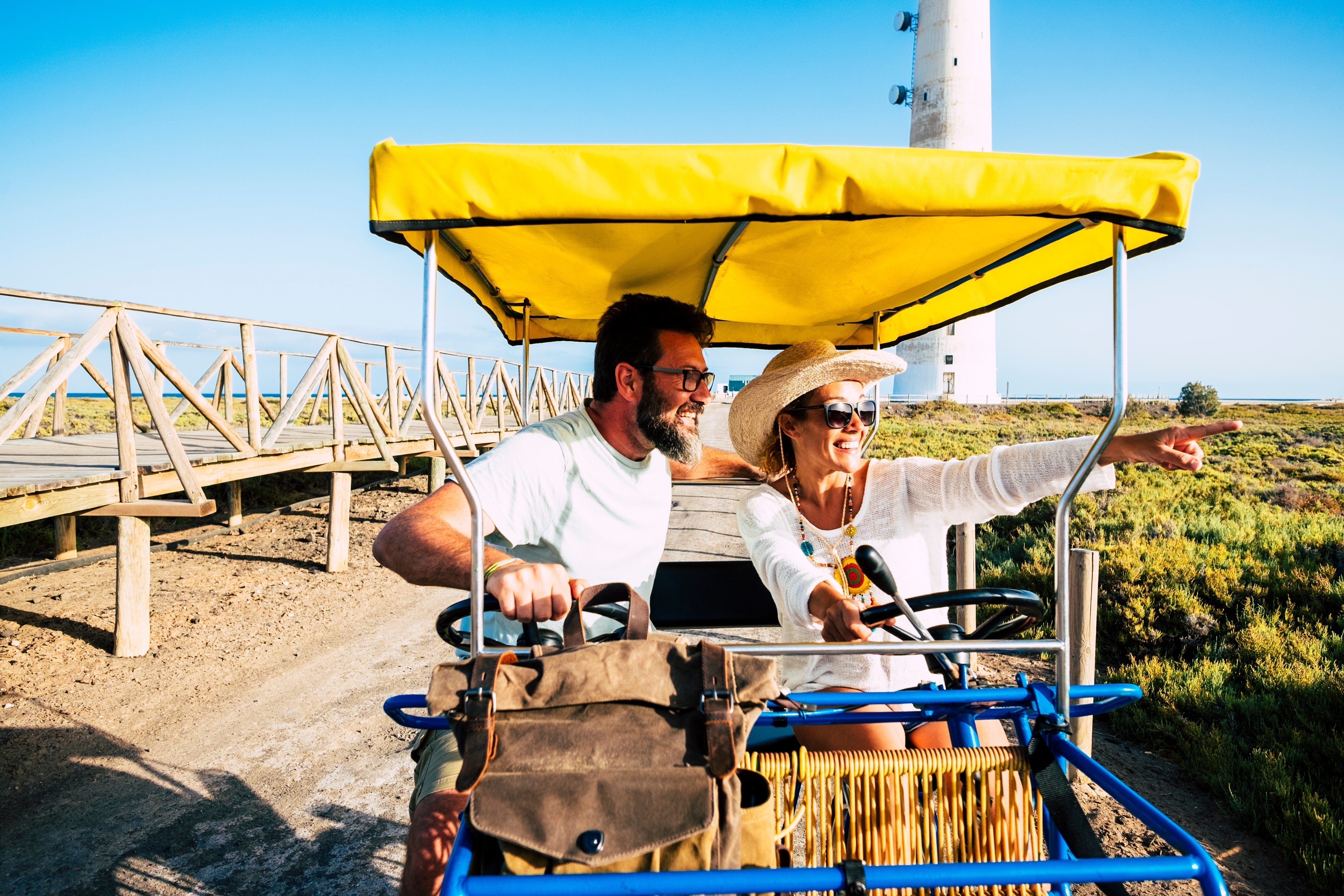 Tourist on a surrey bike enjoying the outdoor activity to stay healthy on vacation.