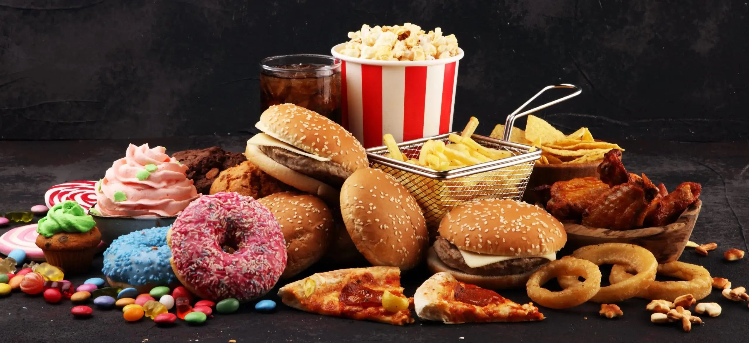 a heap of processed food, donuts, hamburgers, pizza, chips, etc.