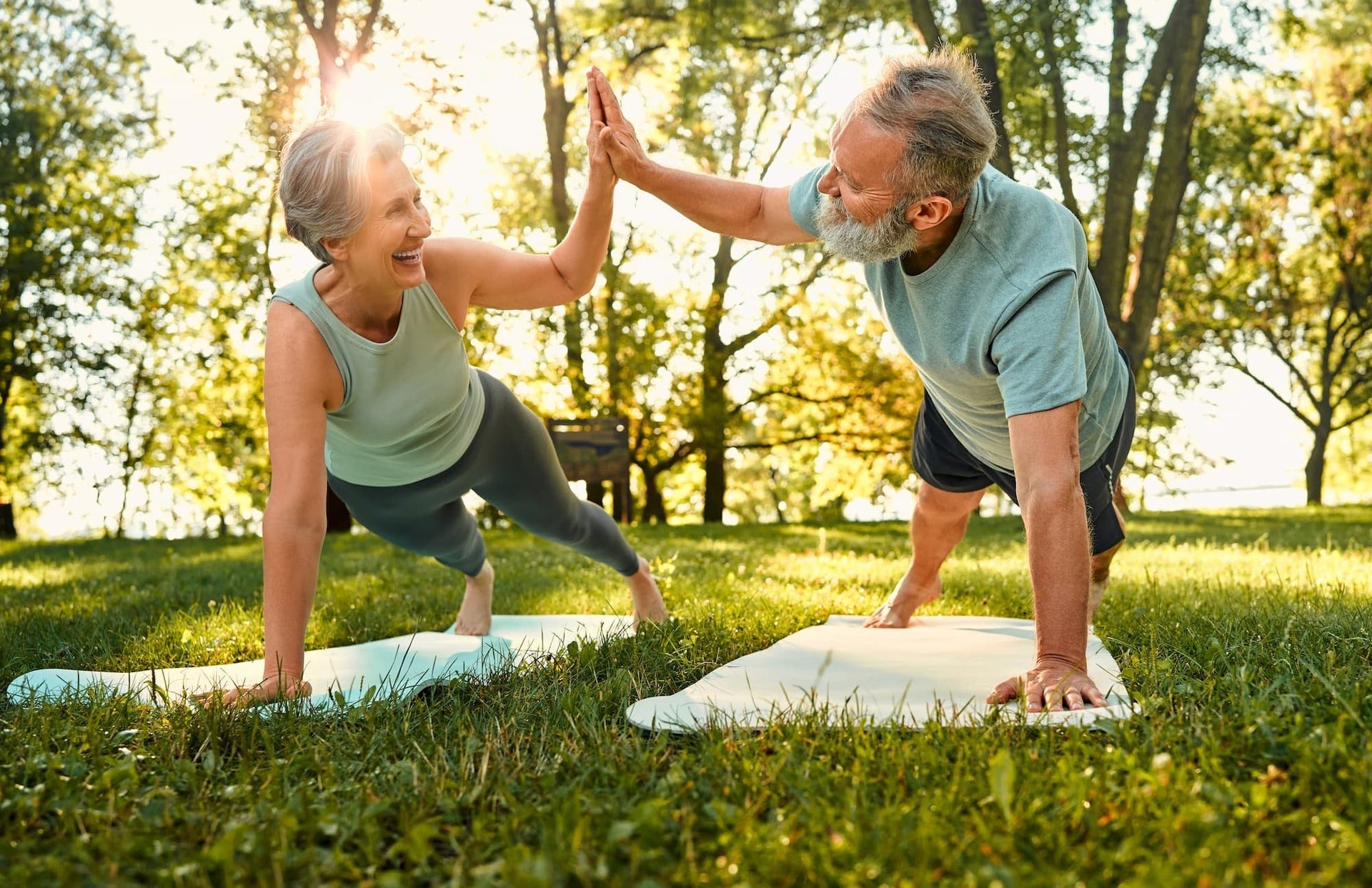 Healthy senior man and woman making high five while in plank position, Why metabolic health matters for aging concept