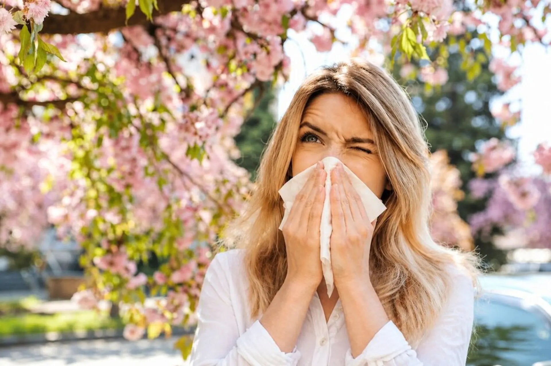 Woman outdoors sneezing, desperate for seasonal allergy relief