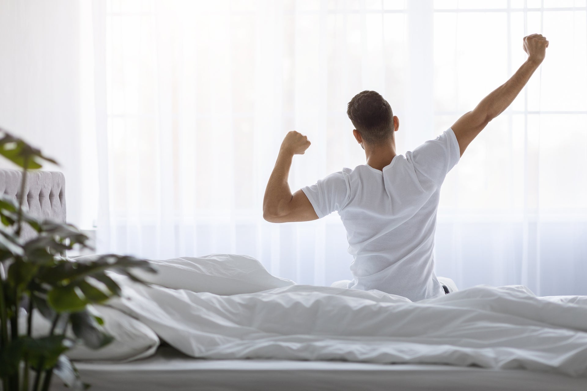 Man stretching bed after waking up in the morning, stretching feels good