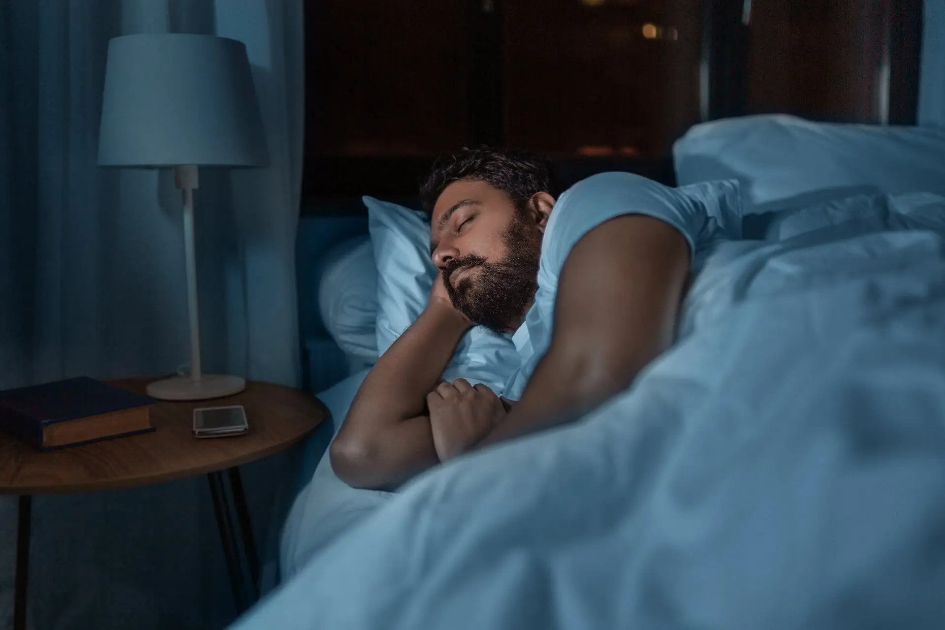 Adult bedtime routine, man sleeping in bed at home at night.